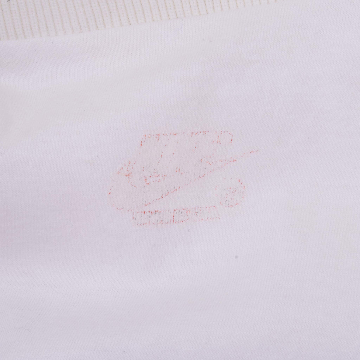 Close-up of faded red Nike label print inside white jacket