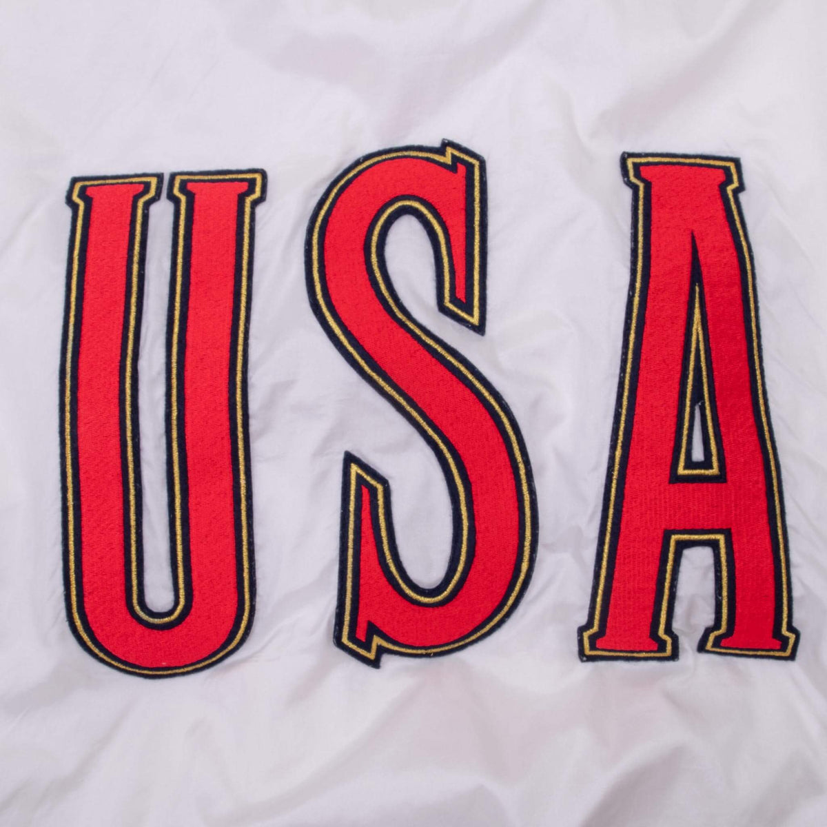 Close-up of large red USA lettering with navy and gold outlines on jacket back