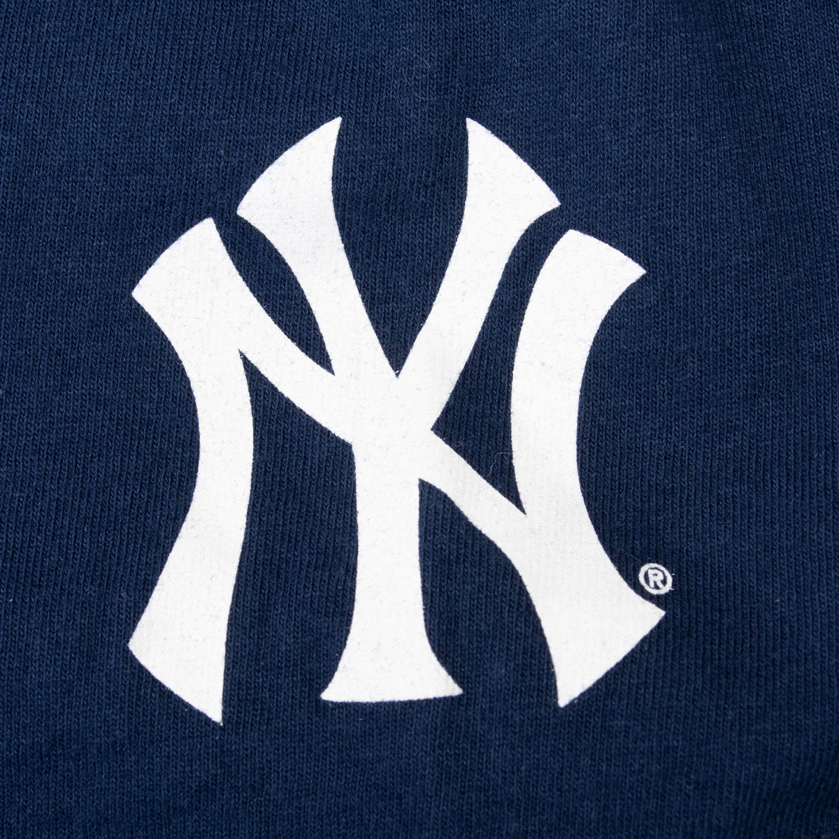Close-up of white New York Yankees NY logo printed on navy sleeve