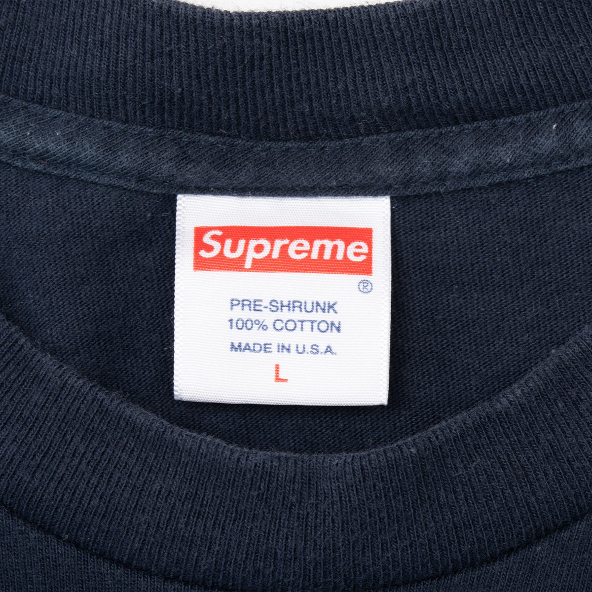 Supreme neck tag marked pre-shrunk, 100% cotton, made in USA and size large