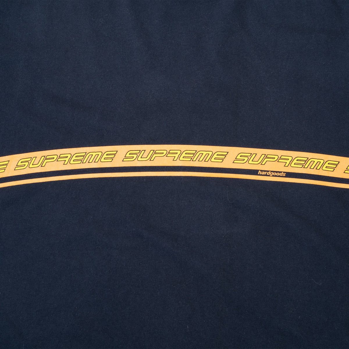Close-up of wraparound orange stripe with repeated outlined Supreme lettering