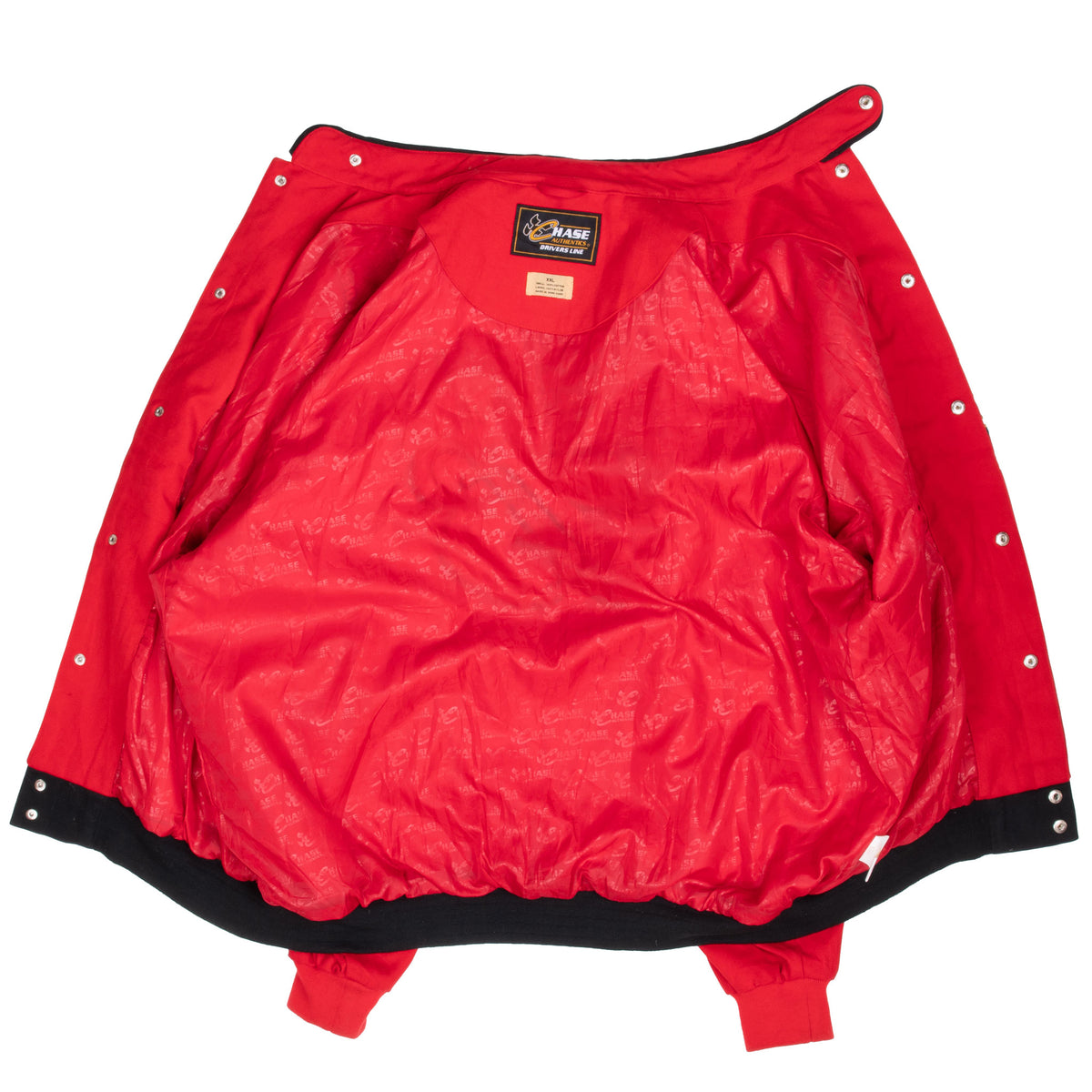 Open red NASCAR jacket showing patterned lining, snap closures, and interior labels