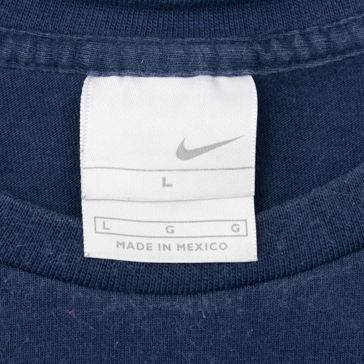 Close-up of Nike neck tag marked size large inside navy blue T-shirt
