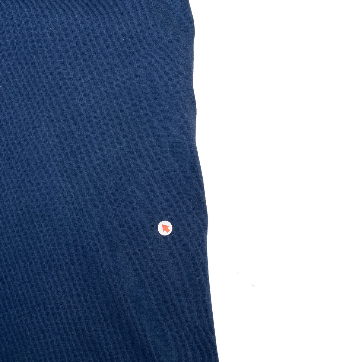 Close-up of blue shirt fabric with a small flaw indicated near the edge