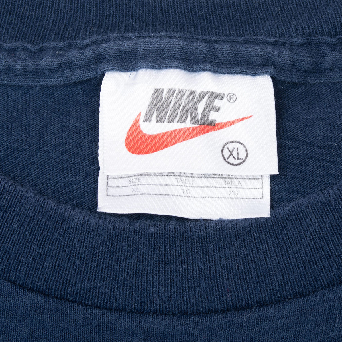 Close-up of Nike neck tag marked XL inside navy T-shirt