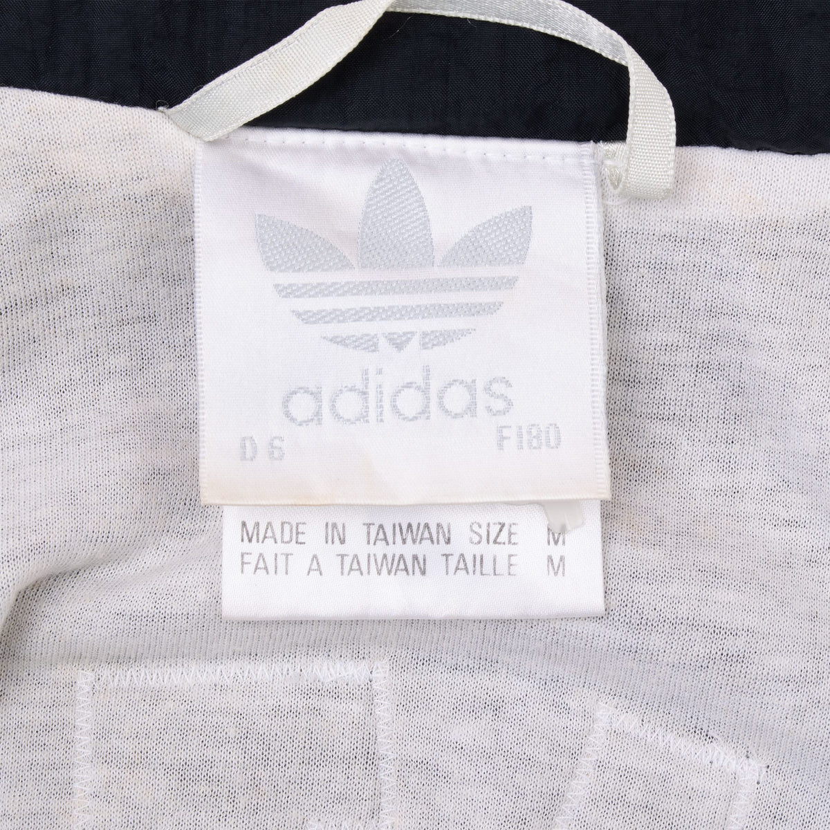 Adidas neck label showing trefoil logo, size M, and Made in Taiwan text