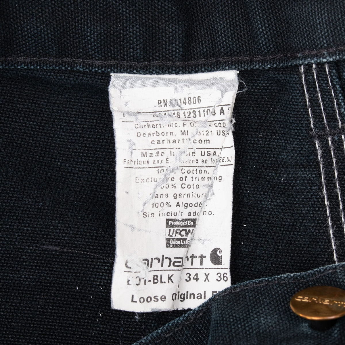 Interior Carhartt care label showing black color, tagged size 34 x 36, and Made in USA