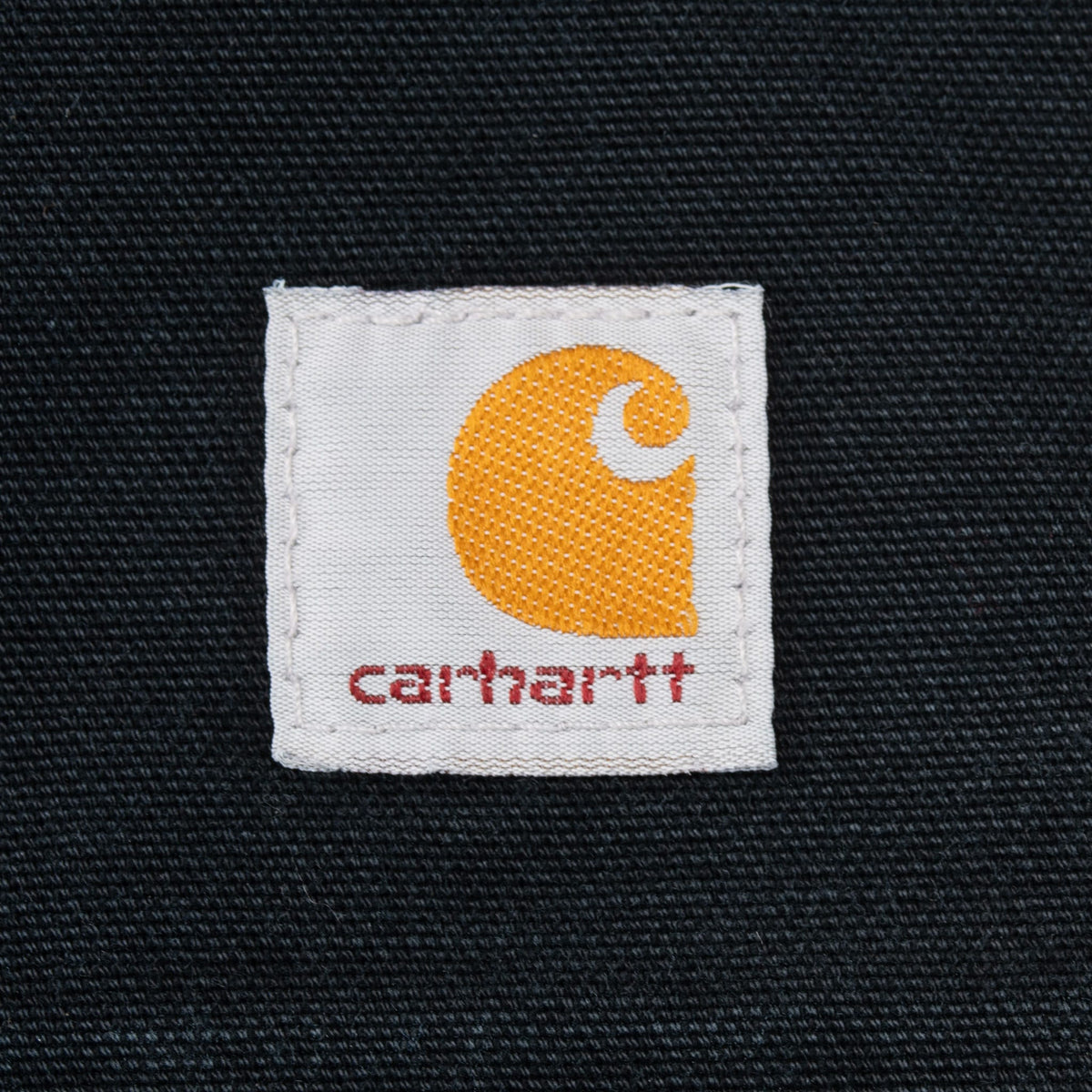 Close-up of Carhartt logo patch on black fabric