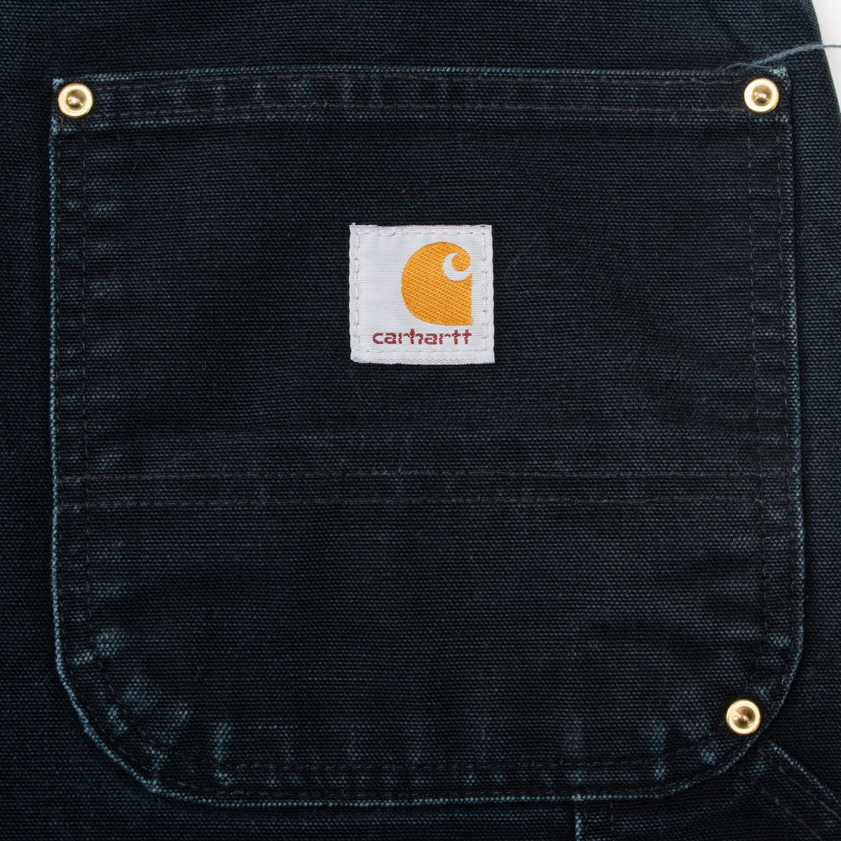 Carhartt logo patch and metal rivets on the black back pocket