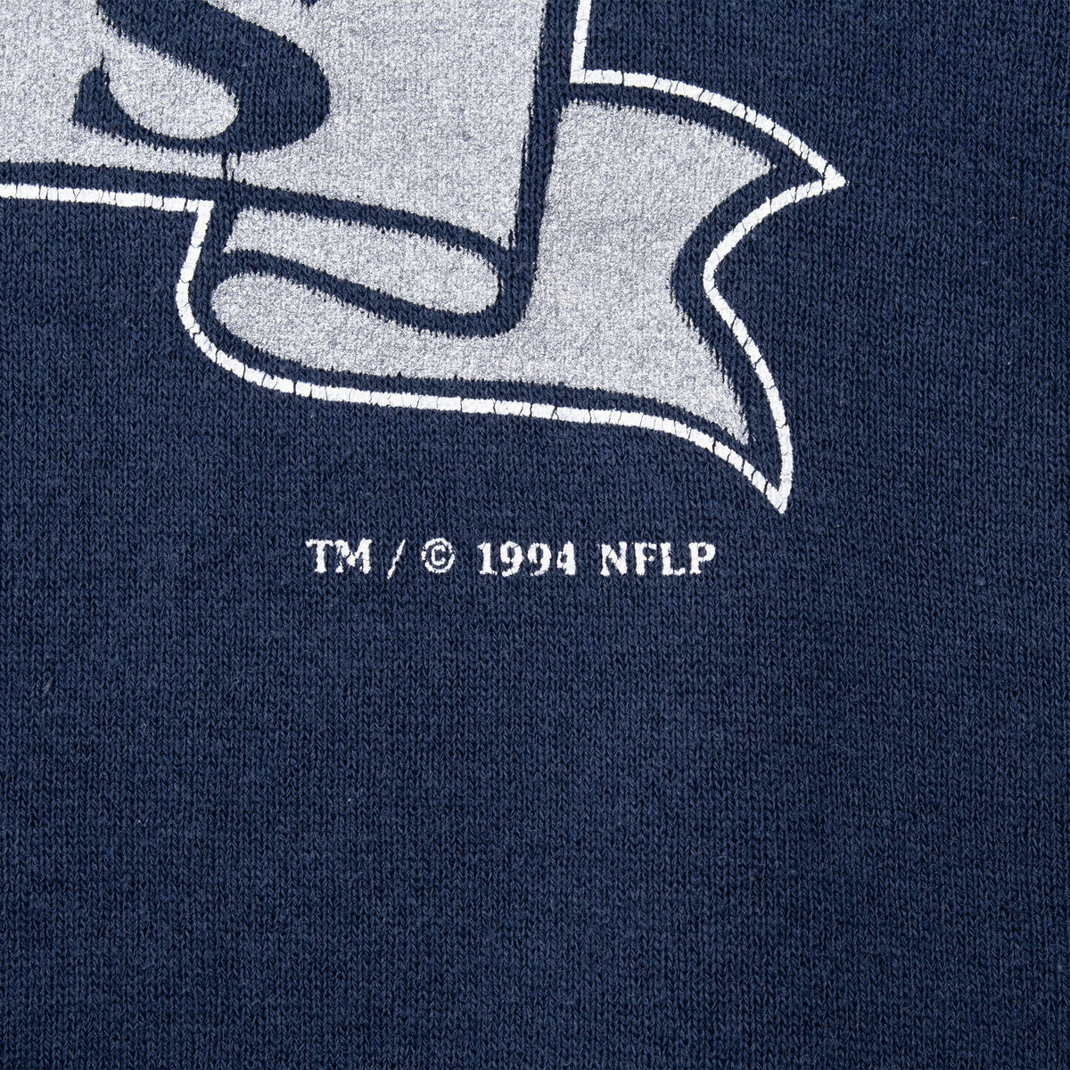 Close-up of 1994 NFLP copyright text beneath the Dallas Cowboys print