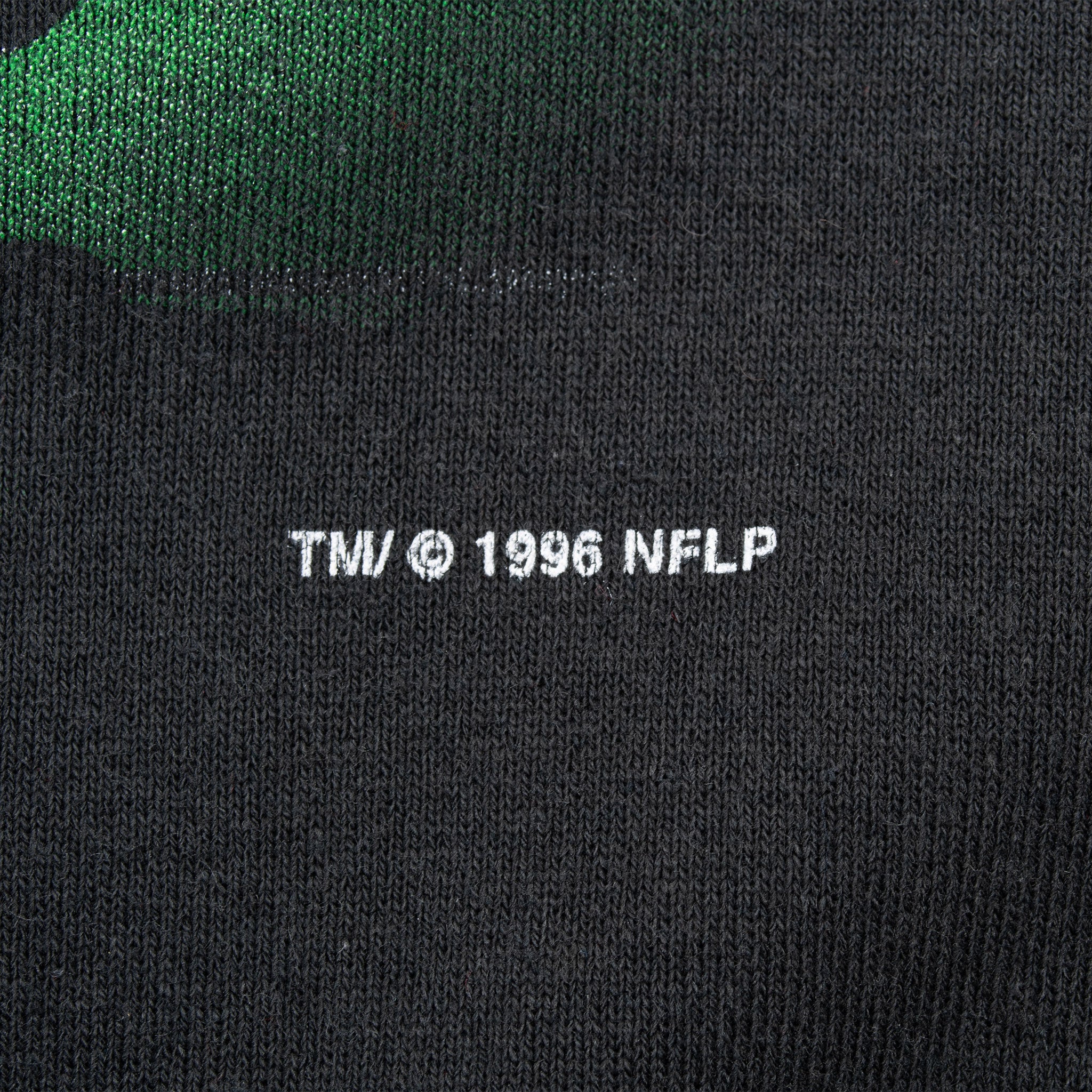 Close-up of 1996 NFL licensing print on black sweatshirt fabric