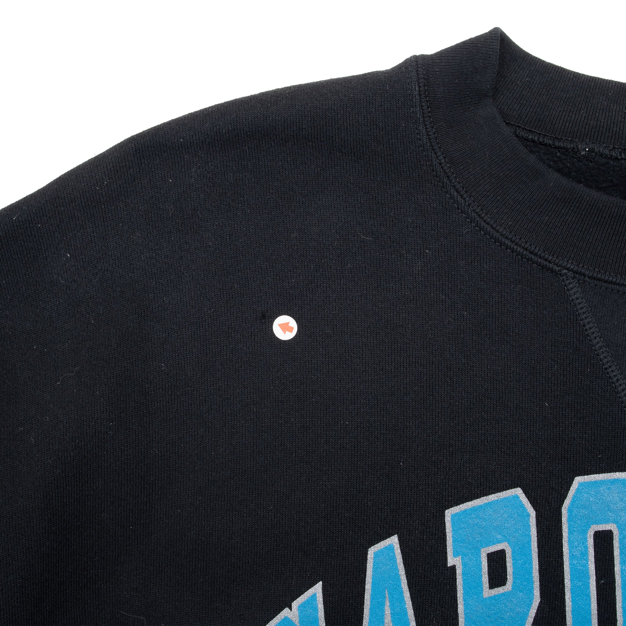 Close-up of small spot on the upper front shoulder of black sweatshirt