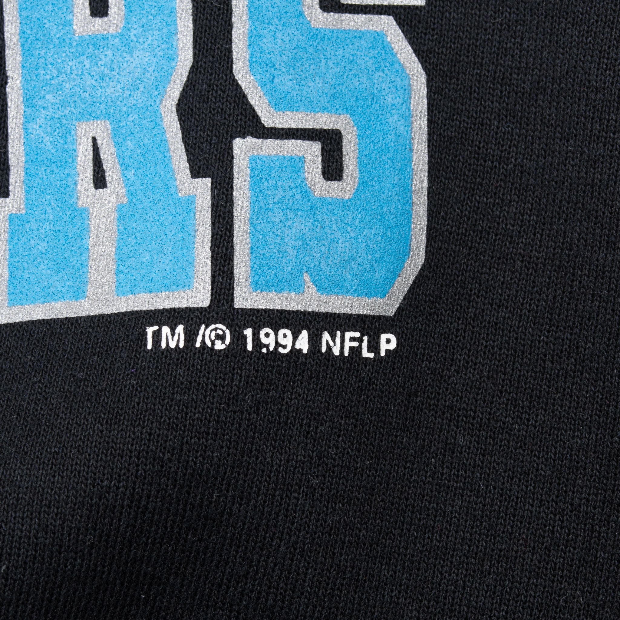 Close-up of 1994 NFLP copyright mark beneath the front graphic