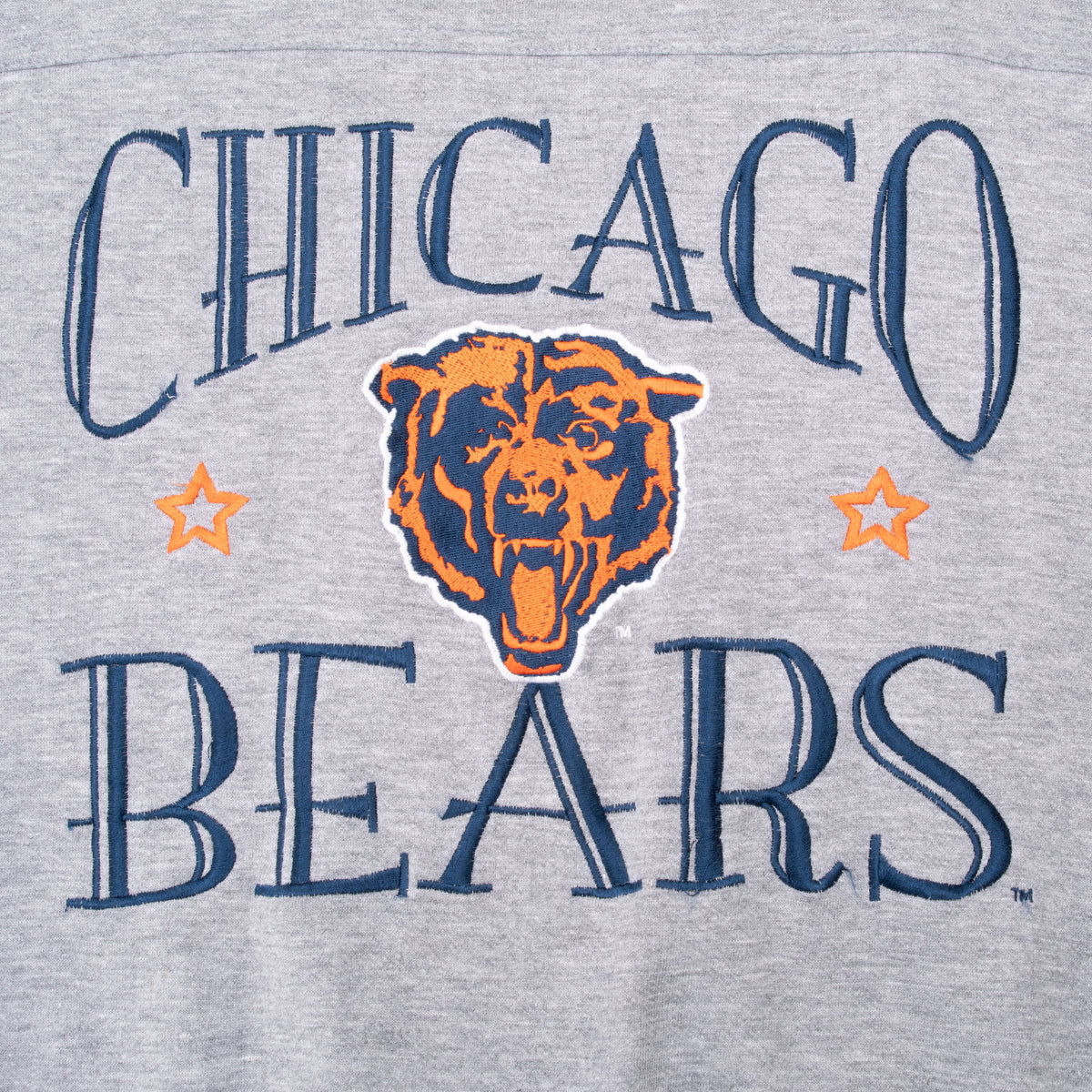 Close-up of navy and orange Chicago Bears logo embroidery on gray sweatshirt