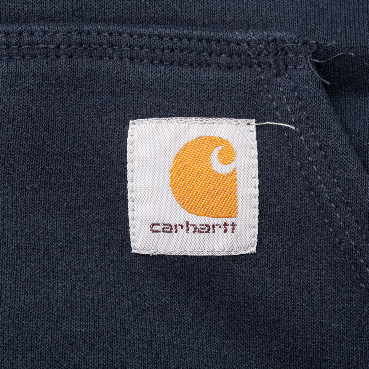Close-up of Carhartt logo patch stitched to navy front pocket