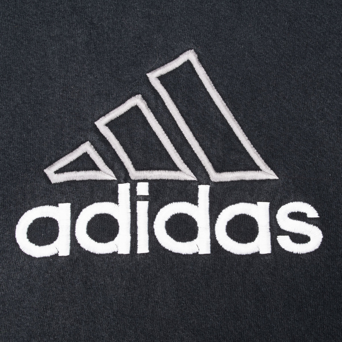 Close-up of white Adidas chest logo embroidered on black hoodie