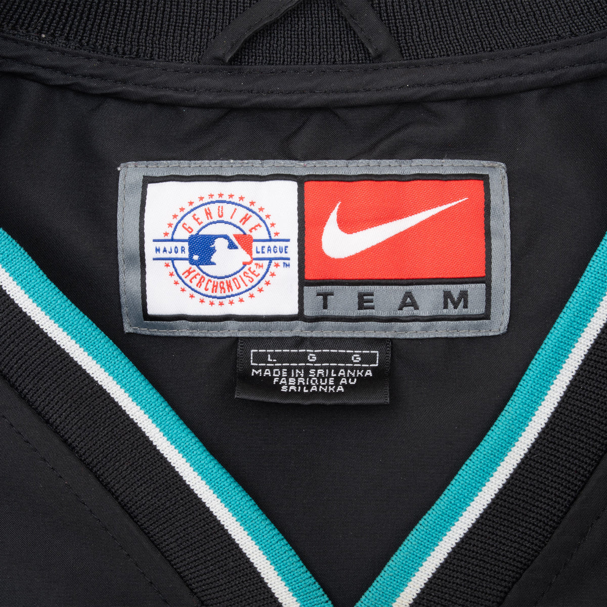 Close-up of Nike Team and MLB merchandise labels inside the jacket collar