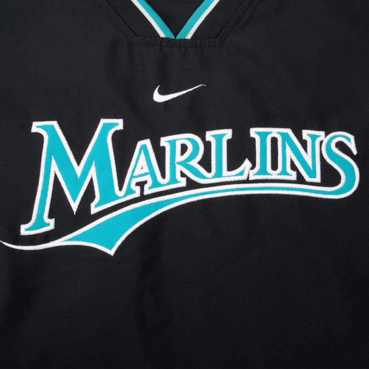 Close-up of teal and white Marlins chest embroidery with Nike Swoosh