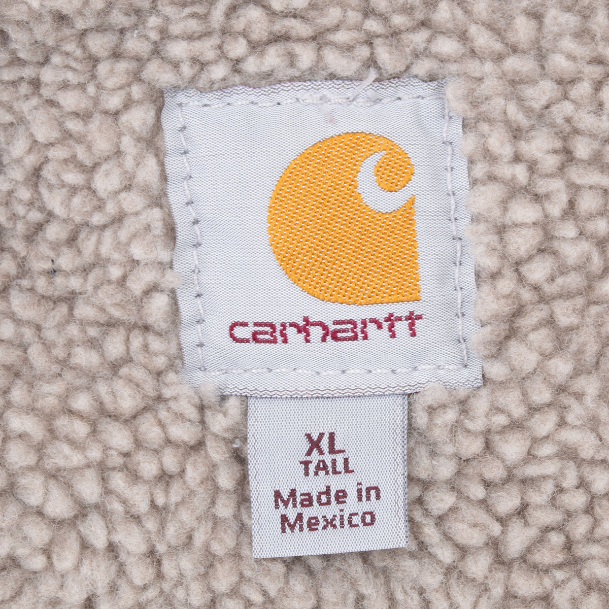 Carhartt neck label and XL Tall size tag against beige sherpa lining