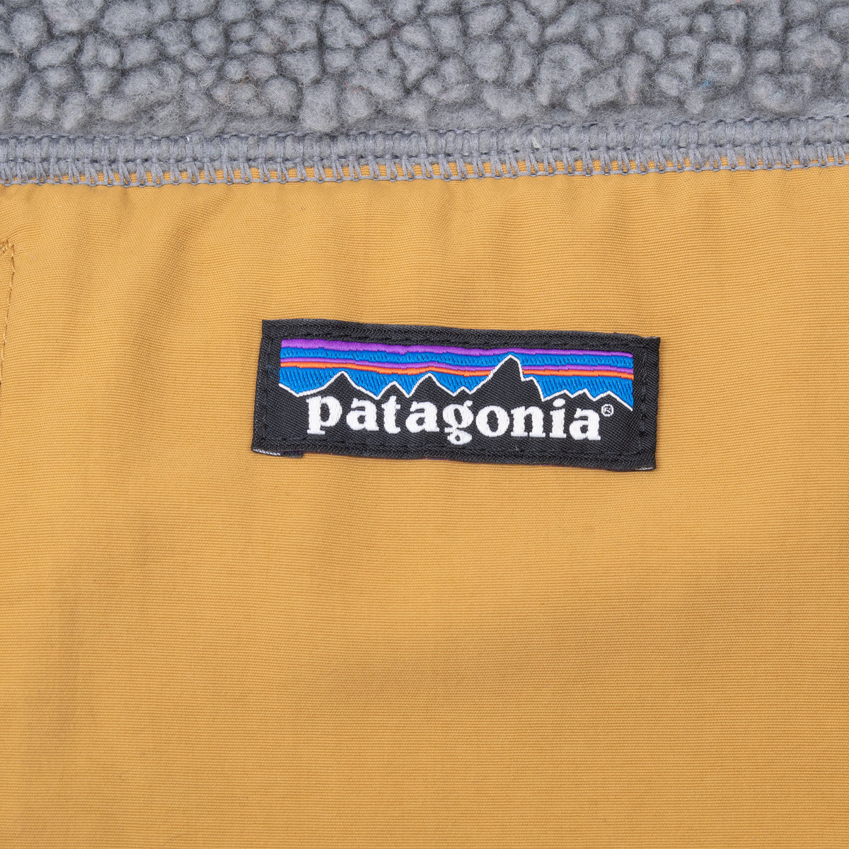 Patagonia logo patch on mustard chest pocket fabric