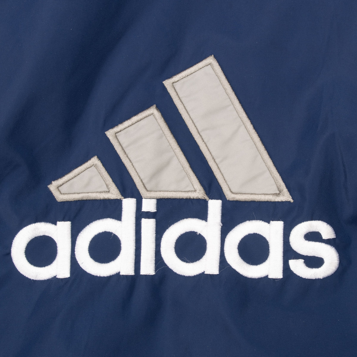 Close-up of large white and gray Adidas back logo on blue fabric