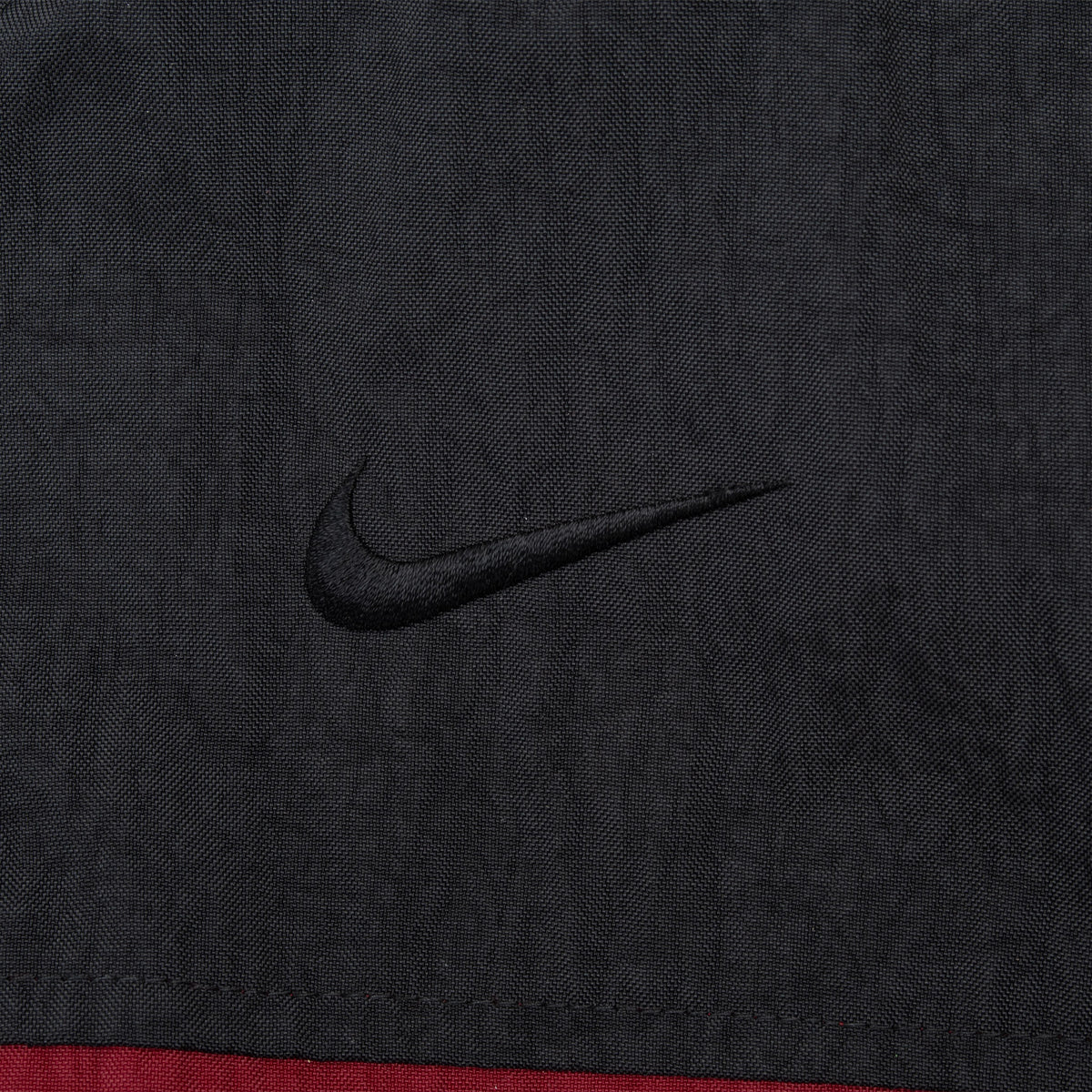 Close-up of black Nike Swoosh embroidery on black jacket chest