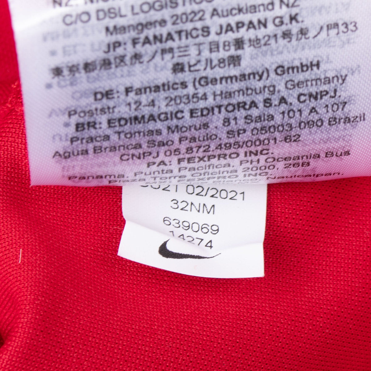 Close-up of interior product and care tags with Nike Swoosh on red jersey fabric
