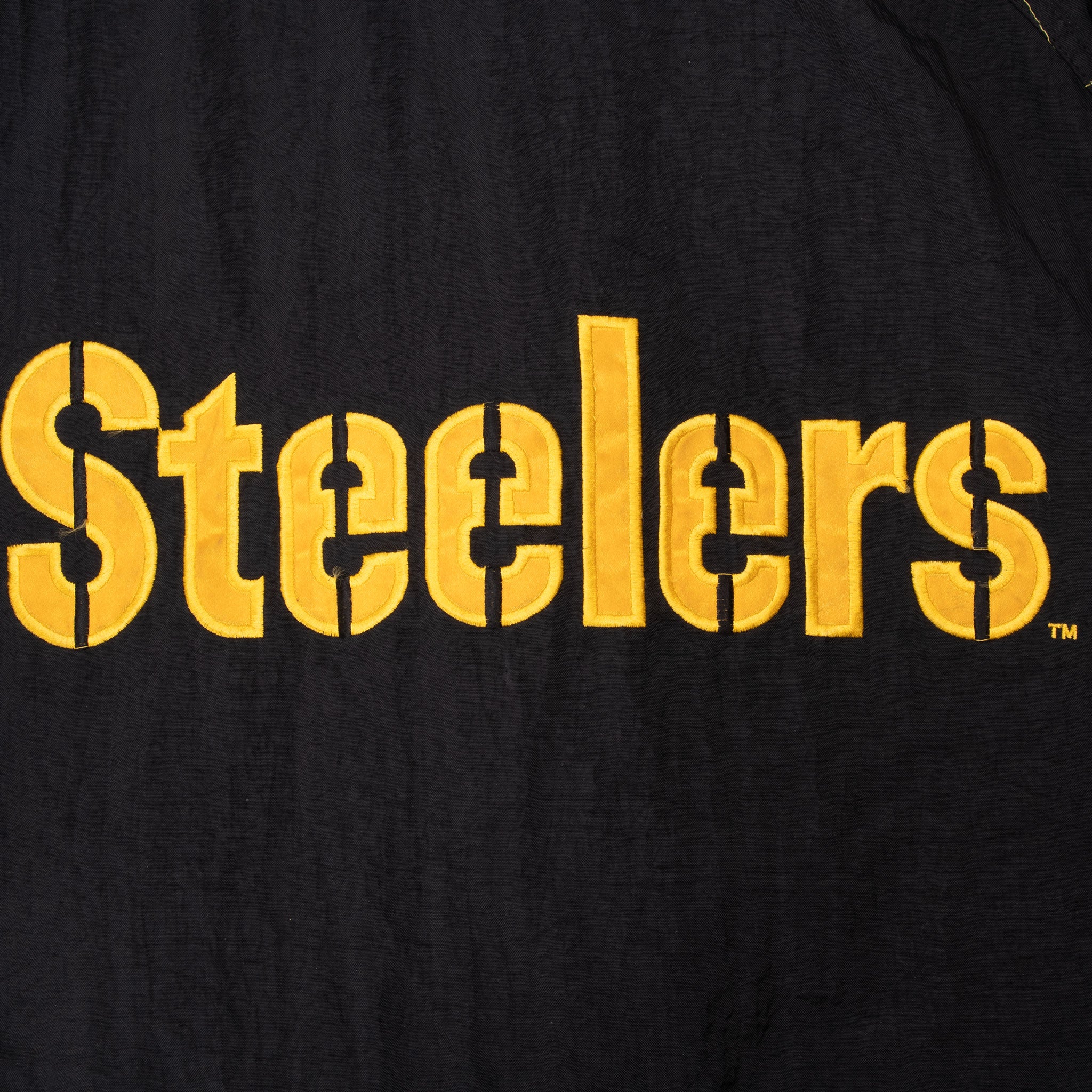 Close-up of large gold Steelers lettering on back of black jacket