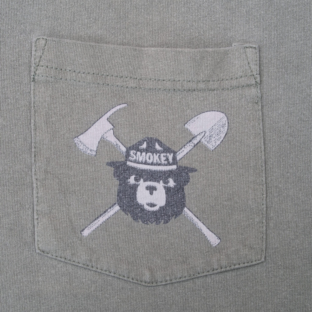 Close-up of Smokey Bear chest pocket print with crossed axe and shovel