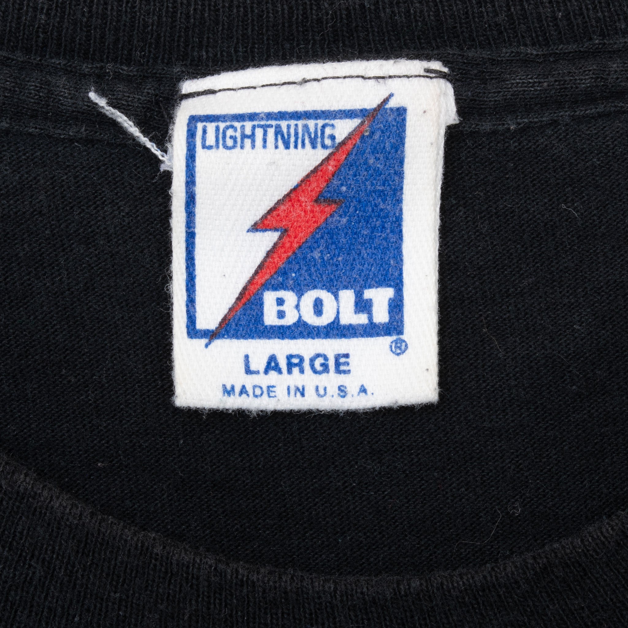 Lightning Bolt neck tag marked large and Made in U.S.A. on black T-shirt