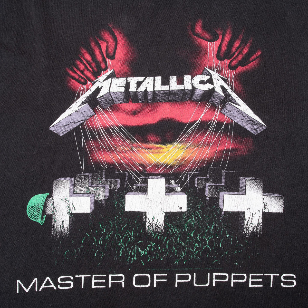 Close-up of Metallica Master of Puppets front graphic with hands, strings and white crosses