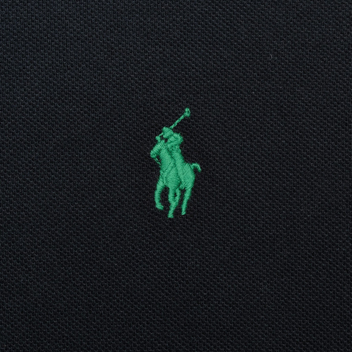 Close-up of green Polo Ralph Lauren pony embroidery on black fabric