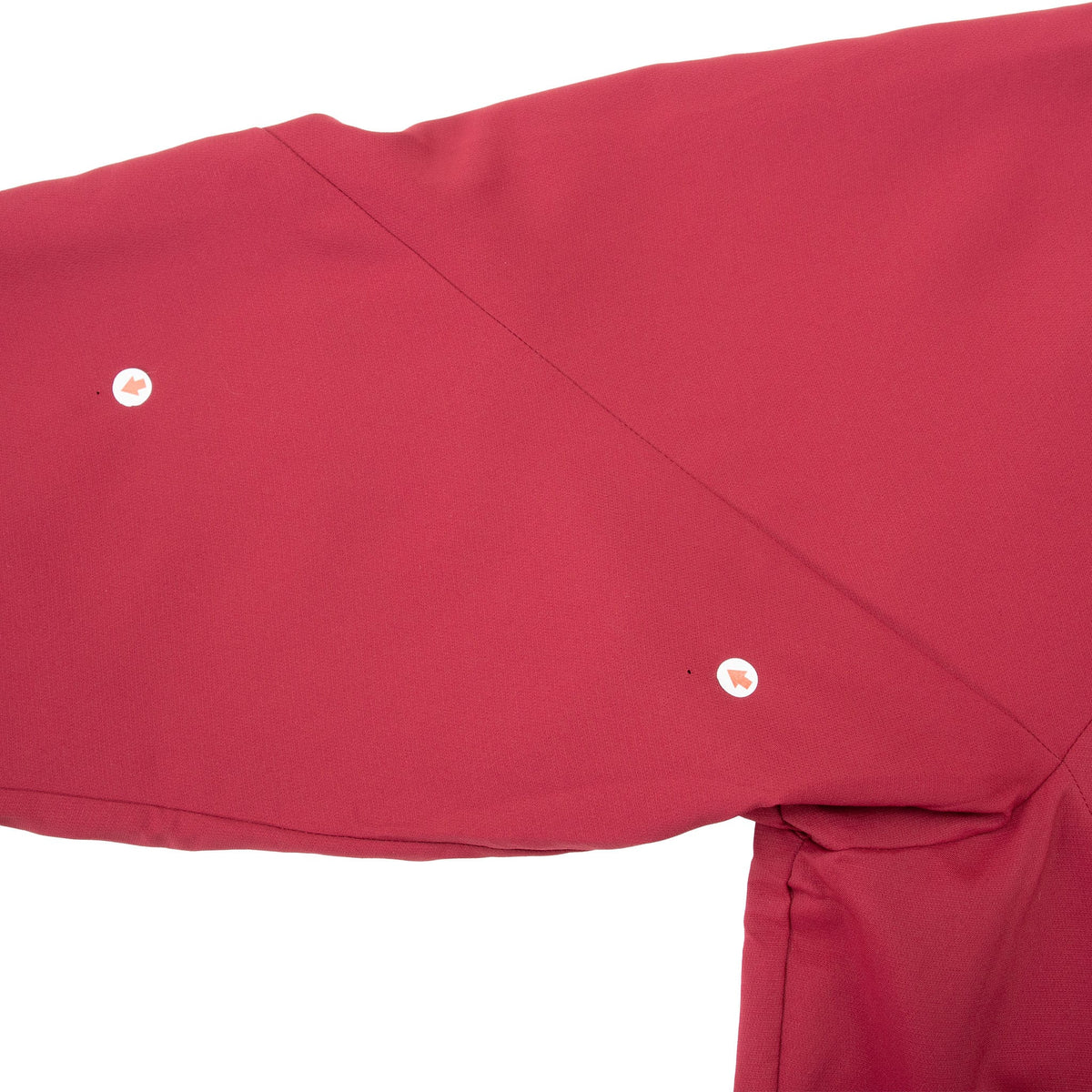 Close-up of burgundy sleeve showing two small light-colored flaws near the seam