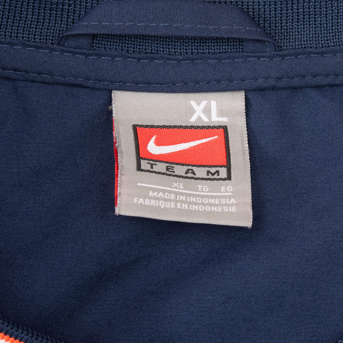 Close-up of Nike Team XL neck tag inside navy Illinois windbreaker