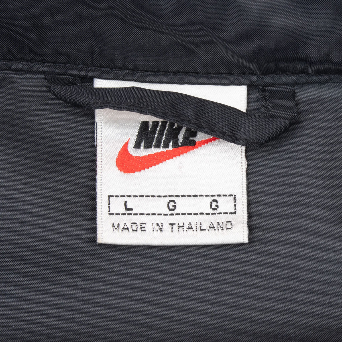 Nike neck label on black windbreaker marked size large and made in Thailand
