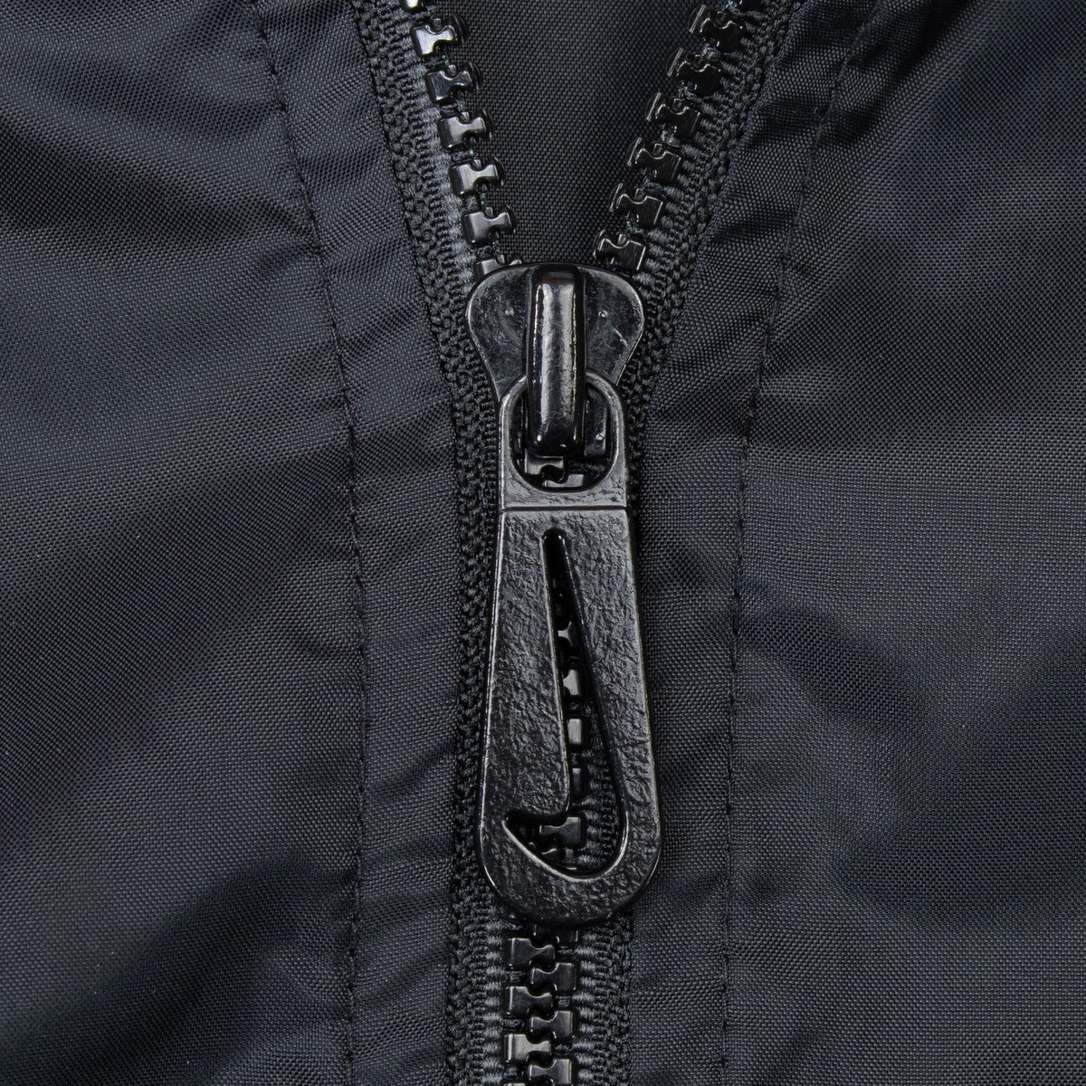 Close-up of black quarter-zip pull and zipper teeth on Nike windbreaker