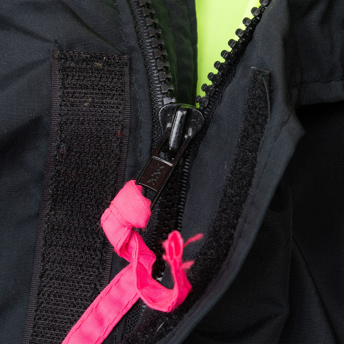 Close-up of covered black front zipper with bright pink zipper pulls