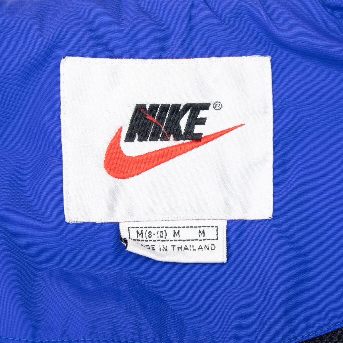 Nike neck label and medium size tag inside blue windbreaker