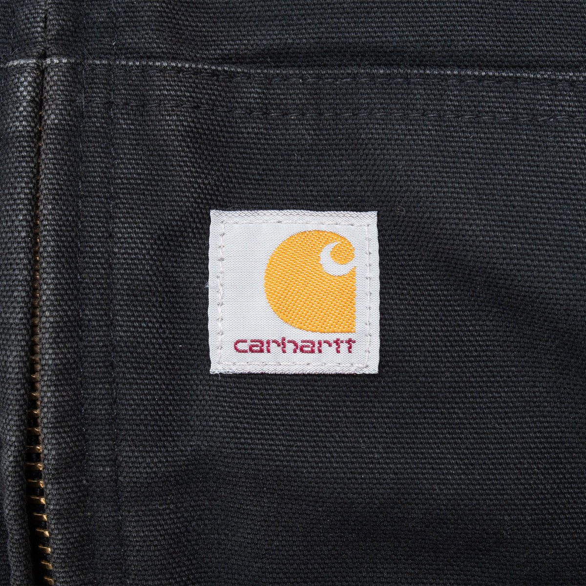 Close-up of Carhartt logo patch on black front pocket