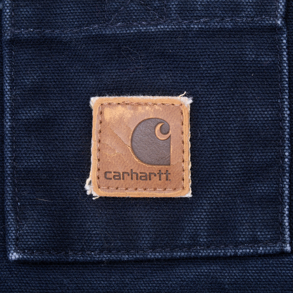 Carhartt logo patch on navy blue jacket chest pocket