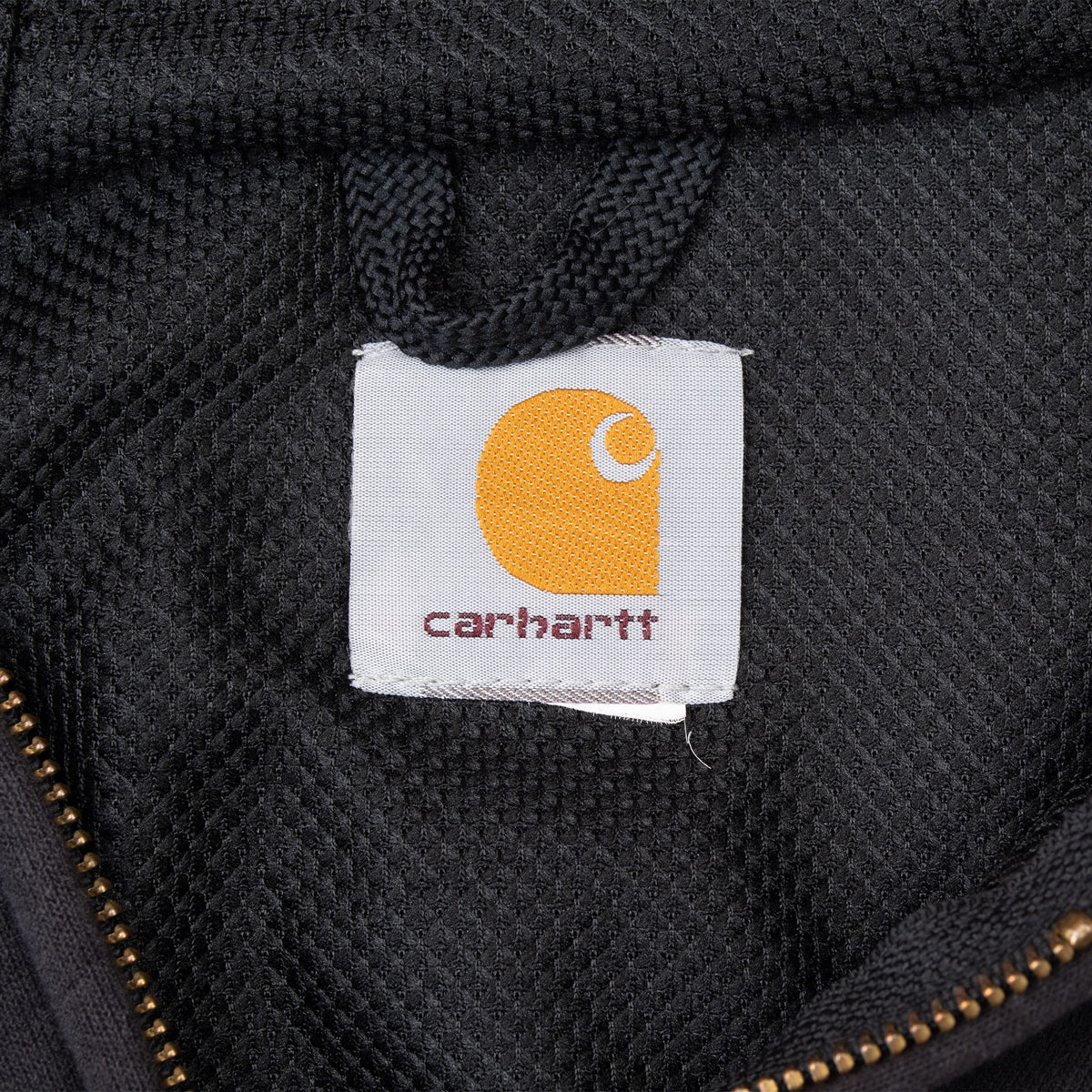 Close-up of Carhartt logo label inside the black hoodie