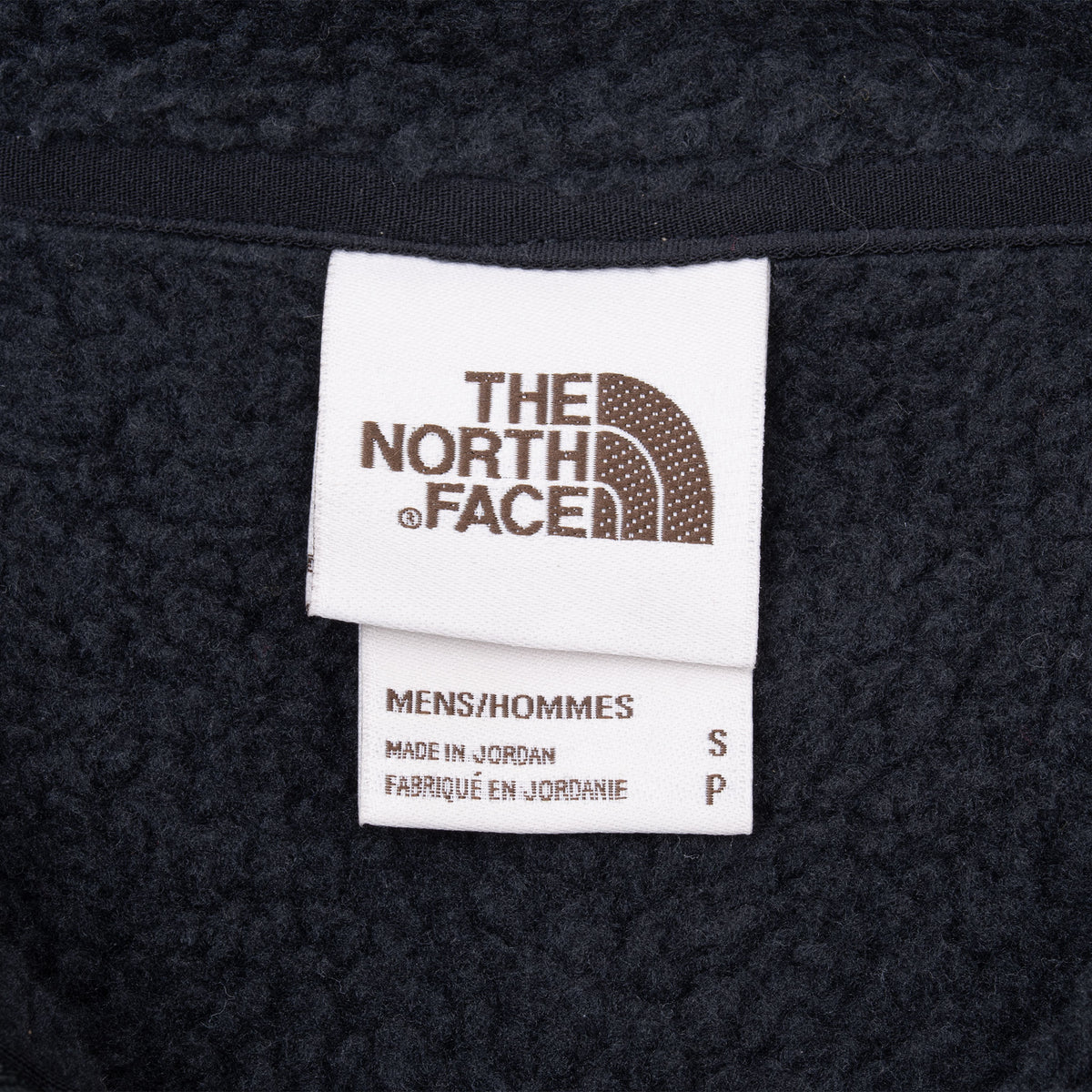 The North Face interior neck label showing men's size small