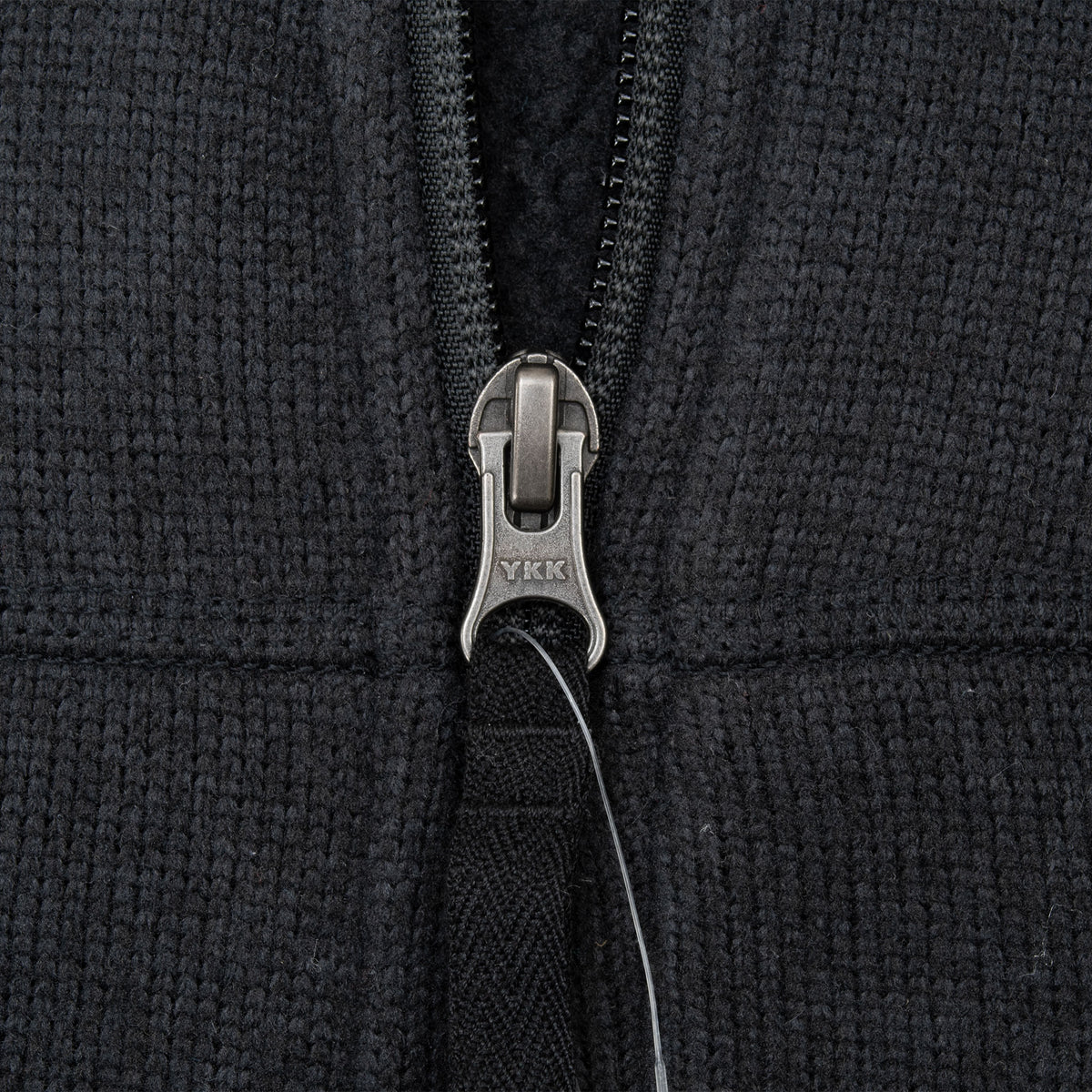 Close-up of the YKK quarter-zip and textured black fabric