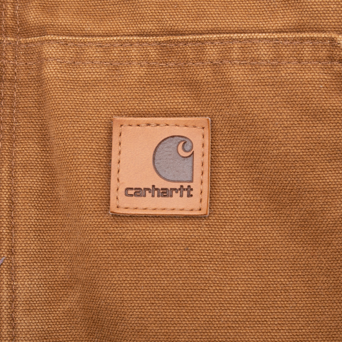 Close-up of Carhartt logo patch on brown front pocket