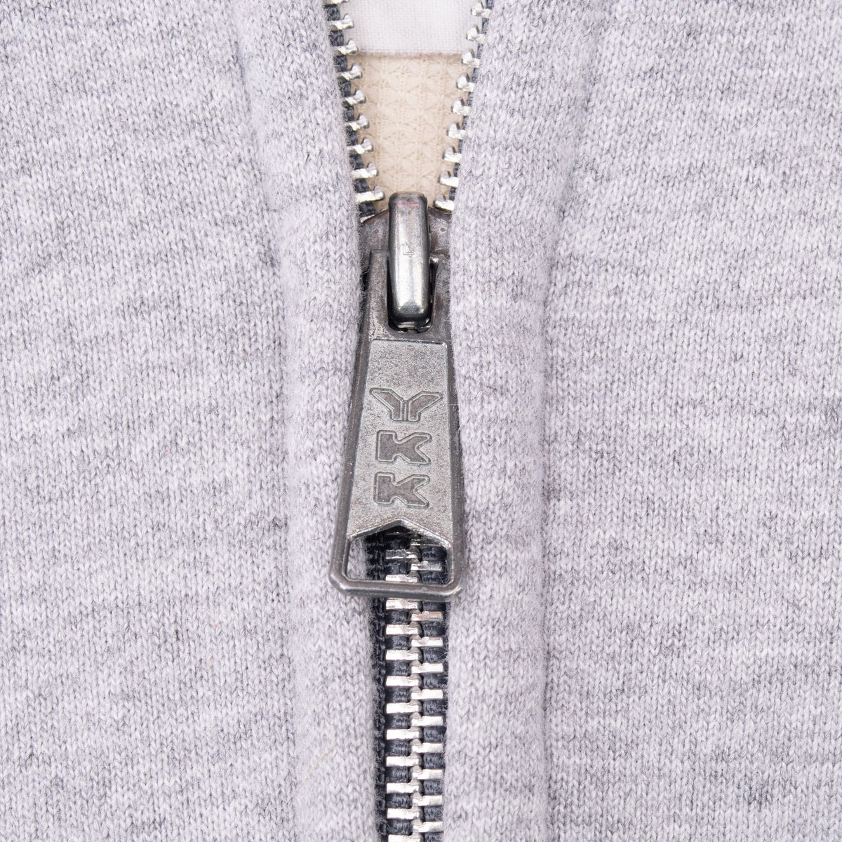 Close-up of metal YKK front zipper on grey Carhartt sweatshirt vest