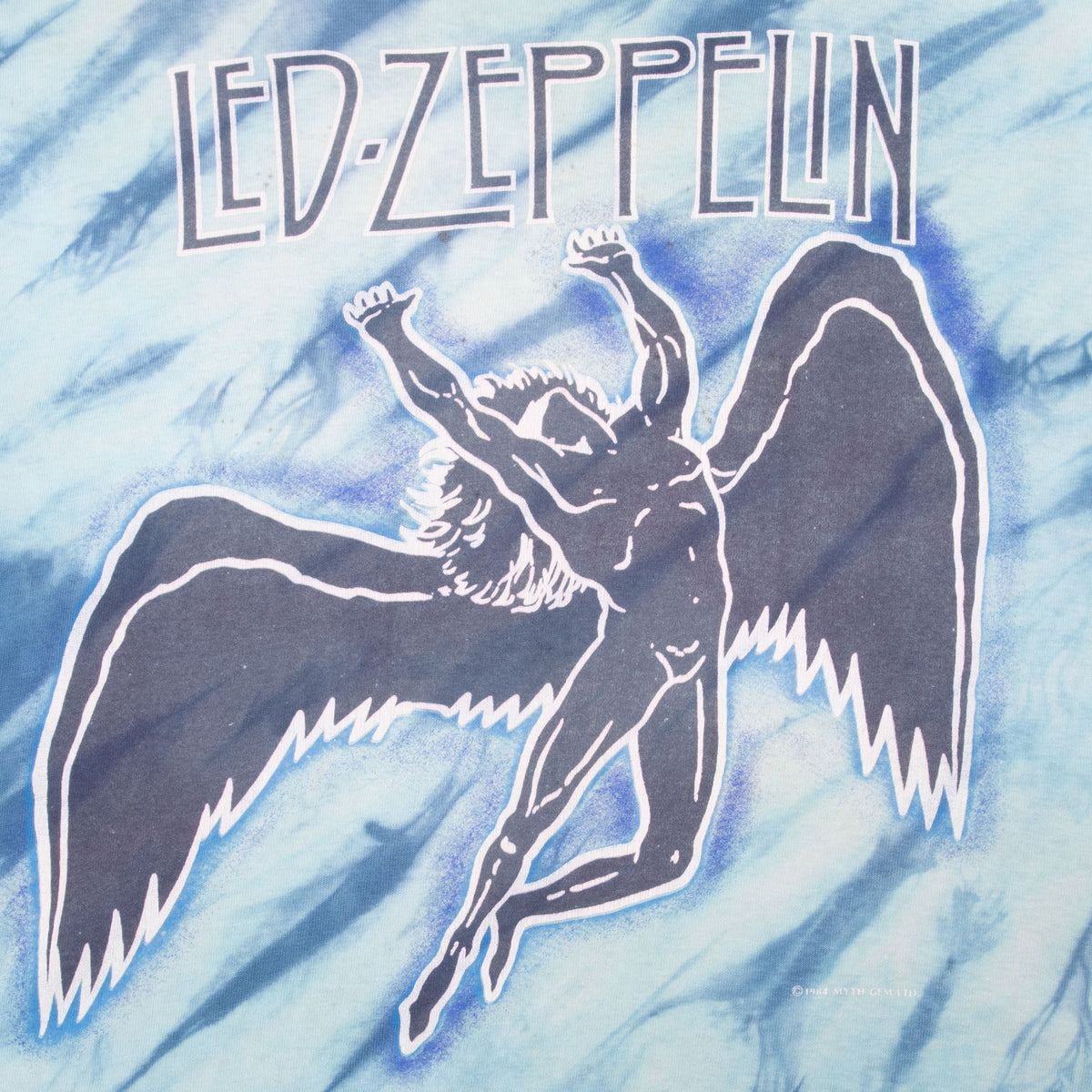 Close-up of Led Zeppelin text and winged figure front graphic on blue tie-dye fabric