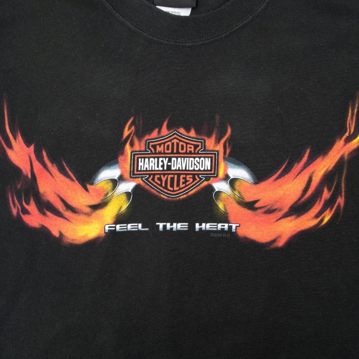 Close-up of Harley-Davidson bar-and-shield, orange flames, and Feel the Heat front print