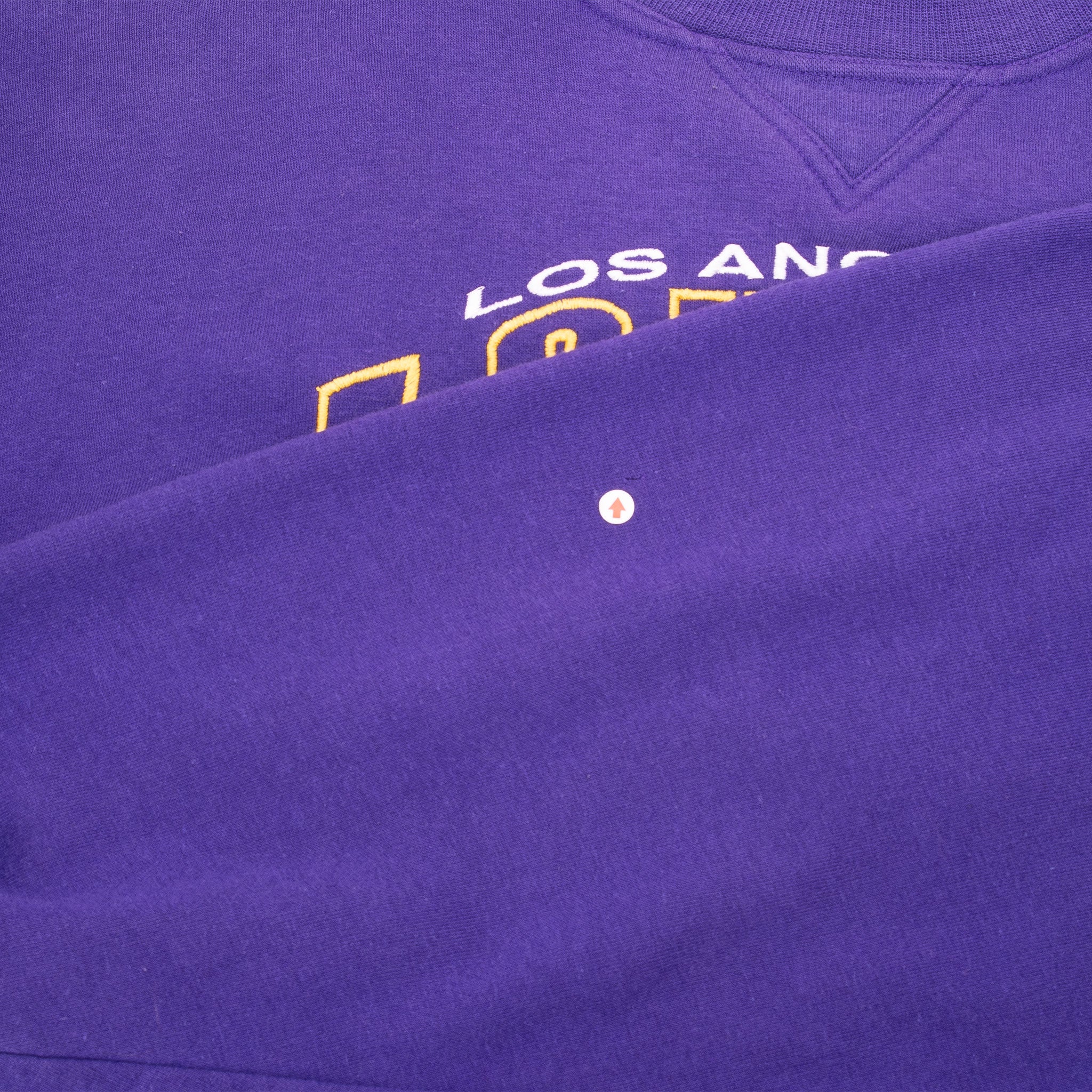 Close-up of purple front fabric with a small spot marked near the Lakers embroidery