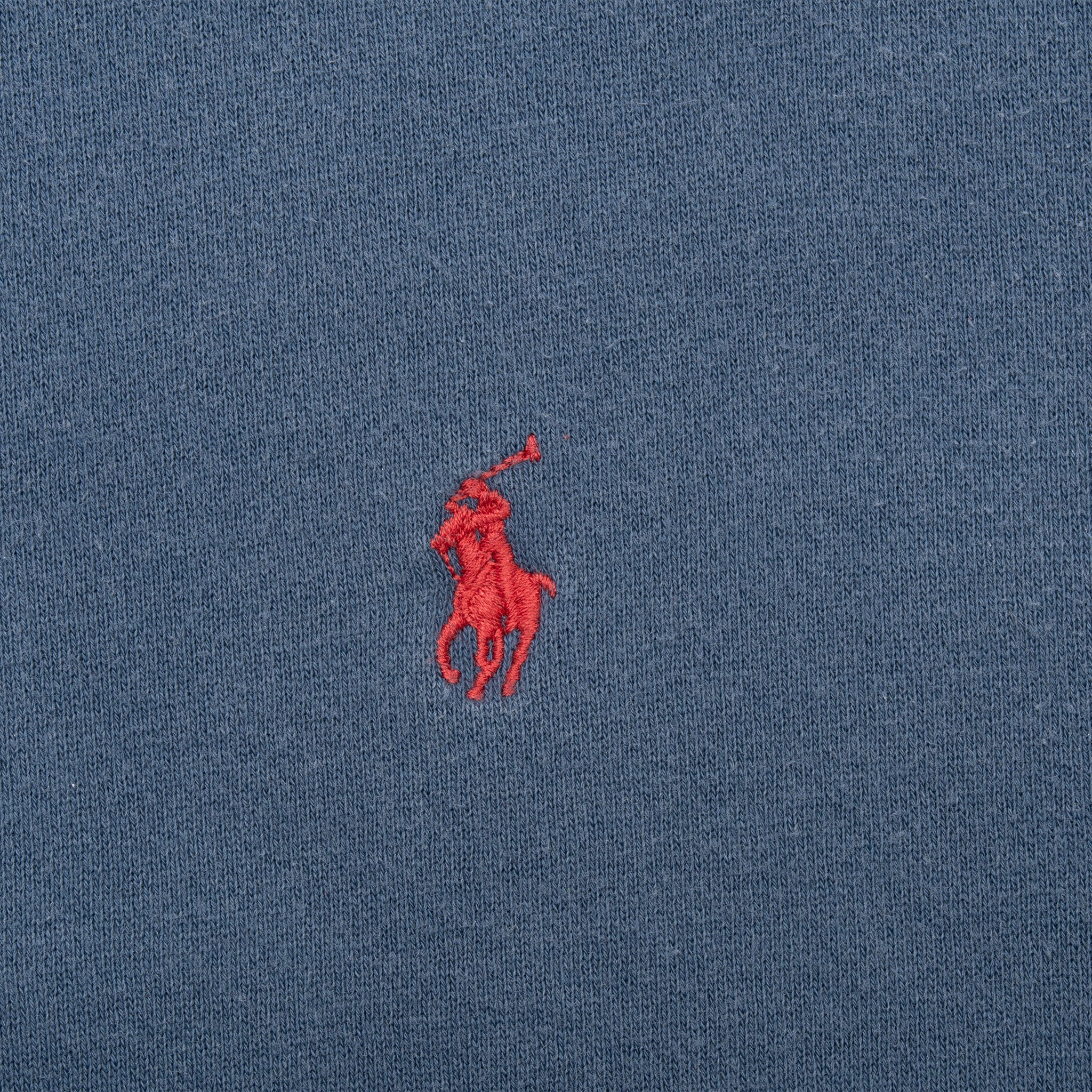 Close-up of red Polo pony embroidery on blue sweatshirt