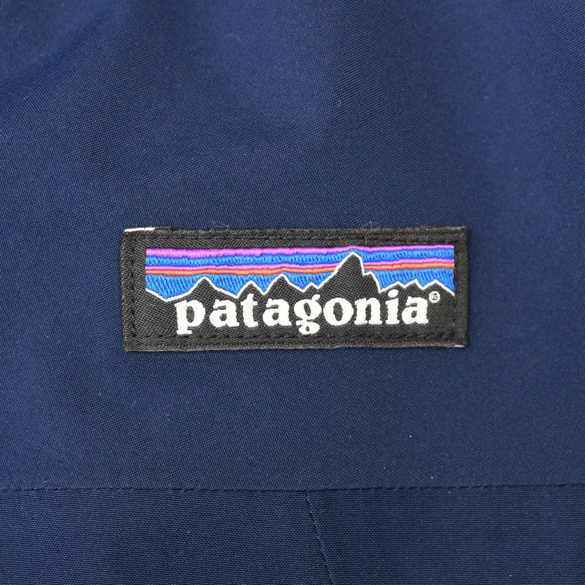 Patagonia logo patch on navy blue jacket chest